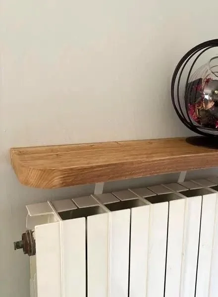 étagère radiateur sans perçage en bois d'échafaudage installée au-dessus d'un radiateur blanc